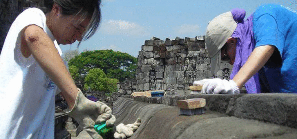Volunteers working together to restore an ancient stone structure