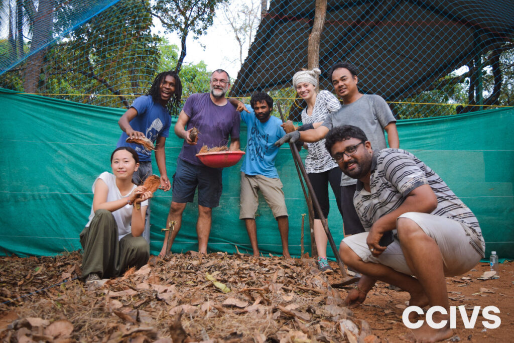 Volunteers from CCIVS gather outdoors, smiling and holding tools and materials used for sustainable gardening and environmental projects